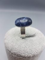 An 18x13 Oval Sodalite Ring with a blue sapphire stone.