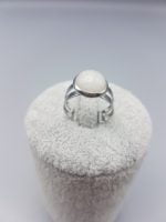 A WHITE JADE RING with a white stone on it.