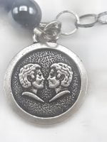 BRACCIALE DI EMATITE E HOWLITE CON CIONDOLO GEMELLI in argento con perlina nera.