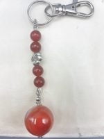A KEYCHAIN WITH CARNELIAN with red and silver bead.