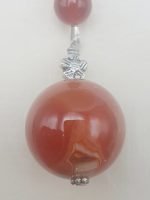 A KEYCHAIN WITH CARNELIAN hanging from a silver chain.