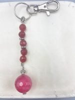 A RUBY JADE KEYCHAIN with a pink stone on top.