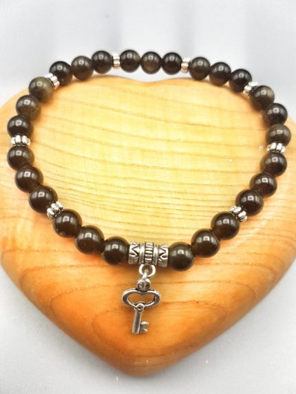 A bracelet with a key and an obsidian pendant.