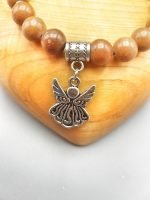 A BROWN JASPER BRACELET WITH ANGEL PENDANT with angel pendant.