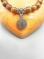 A BRONZITE BRACELET WITH TREE OF LIFE PENDANT with silver tree of life charm.
