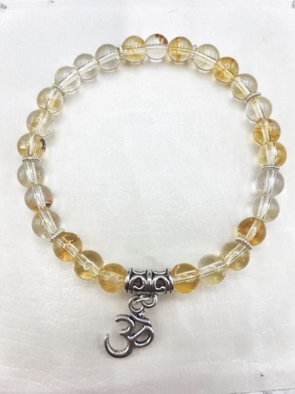 A bracelet with citrine quartz beads and an OM pendant.