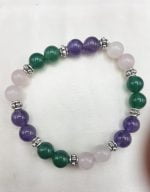 A BRACCIALE DI AGATA VERDE, AMETISTA E QUARZO ROSA con perline viola, verdi e bianche.