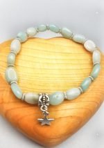 A bracelet with a star pendant and green jade beads.