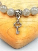 A LABRADORITE BRACELET WITH KEY PENDANT with silver key pendant.