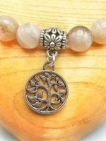 A PINK MOONSTONE BRACELET WITH TREE OF LIFE PENDANT with the charm of the tree of life.