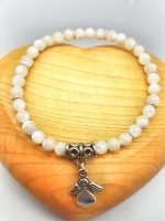A white beaded bracelet and angel pendant.