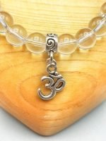 An 8MM ROCK CRYSTAL BRACELET WITH OM PENDANT with om pendant.