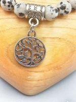 A DALMATIAN JASPER BRACELET WITH LIFE TREE PENDANT with silver tree of life charm.