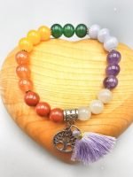 A colorful BRACELET OF THE SEVEN CHAKRAS WITH PENDANT with tassel and tree of life charm.