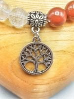 A BRACELET OF THE SEVEN CHAKRAS WITH PENDANT with a tree of life pendant on top.