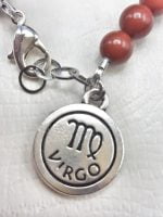 A bracelet with the product name on it RED JASPER AND HEMATITE MEN'S BRACELET WITH VIRGIN PENDANT.