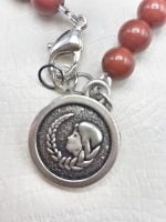 A necklace with pearl MEN'S BRACELET OF RED JASPER AND HEMATITE WITH VIRGIN PENDANT and charm in sterling silver.