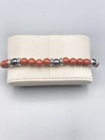 A bracelet with red coral beads and silver beads.
