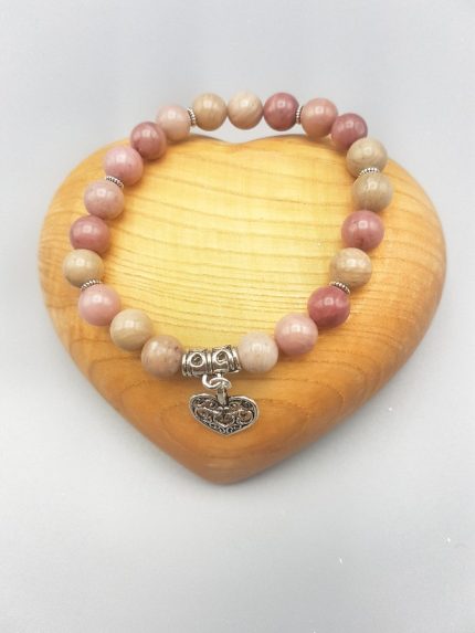 A pink stone bracelet with a silver heart pendant.