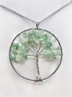 A GREEN AVENTURINE TREE OF LIFE NECKLACE with green crystals on a silver chain.