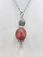 Una collana con un CIONDOLO DI DIASPRO ROSSO su una catena d'argento.