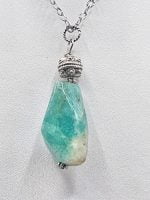 A stone amazonite pendant on a silver chain.