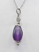 A purple fluorite pendant on the silver chain.