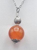 SPHERICAL CARNELIAN PENDANT is hung on a silver chain.