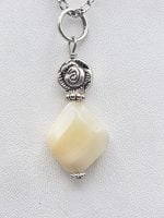 A mother-of-pearl pendant on a silver chain.