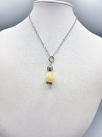 The YELLOW CALCITE PENDANT on a silver chain.