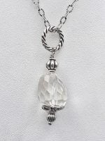 A SILVER NECKLACE with a ROCK STONE CRYSTAL PENDANT.