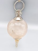 A spherical rose quartz pendulum hanging from a silver chain.