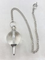 Un pendolo in cristallo di rocca sferico con una catena d'argento attaccata ad esso.