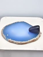 AN INCENSE BURNER SLICE OF BLUE AGATE is placed on a white plate.