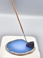 AN INCENSE BURNER SLICE OF BLUE AGATE with a wooden stick inside.