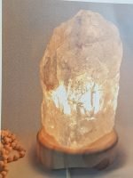 A ROCK CRYSTAL LAMP 2/3 KG with a stone on it.