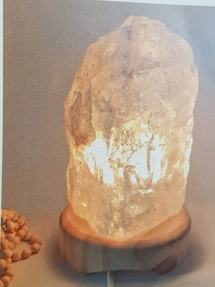 UNA LAMPADA CRISTALLO DI ROCCA 2/3 KG con sopra un sasso.