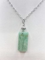 A green jade pendant on a silver chain, inspired by the AMAZONITE BARREL PENDANT.