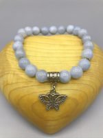 A bracelet with a butterfly pendant and blue jade beads.