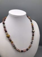 A RHODONITE AND MOOKAITE NECKLACE with pink, yellow and brown beads on mannequin.