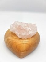 A RAW ROSE QUARTZ on a wooden heart.