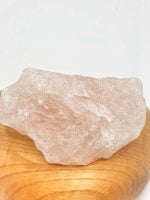 A RAW ROSE QUARTZ on wooden board.