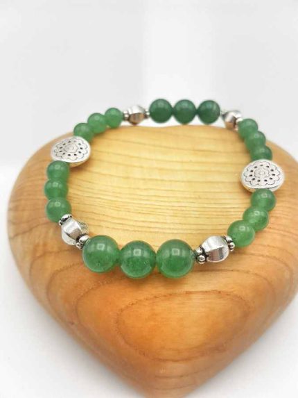 A bracelet with green aventurine beads and mixed silver pendants.