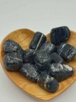A heart-shaped wooden bowl filled with SEMI-TUMBLED BLACK TOURMALINE stones.