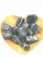 A wooden bowl filled with SEMI-TUMBLED BLACK TOURMALINE stones in the shape of a heart.