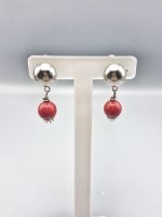 A pair of clip-on earrings with red coral.