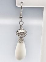 A silver DROP WHITE AGATE EARRINGS earring with a white agate drop hanging.