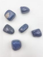 A collection of DURMOTIERITE stones tumbled on a white surface.