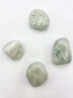 Four stones TUMBLED GREEN JADE arranged on a white surface.
