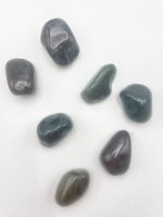 A group of green and black BURATTATA MOSS AGATE stones on a white surface.